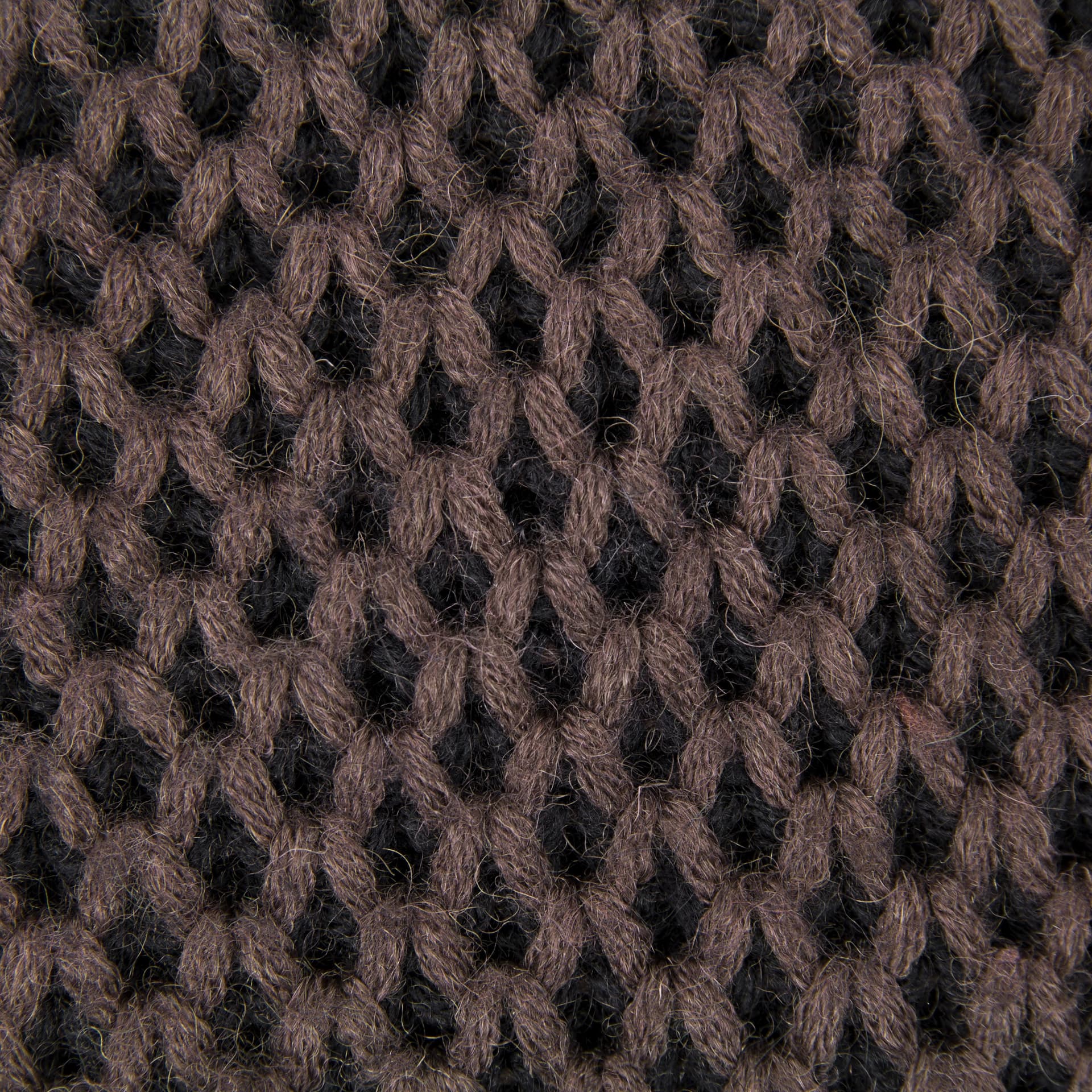 A close view of brown and black knitted fabric showing the loops of the stitch.